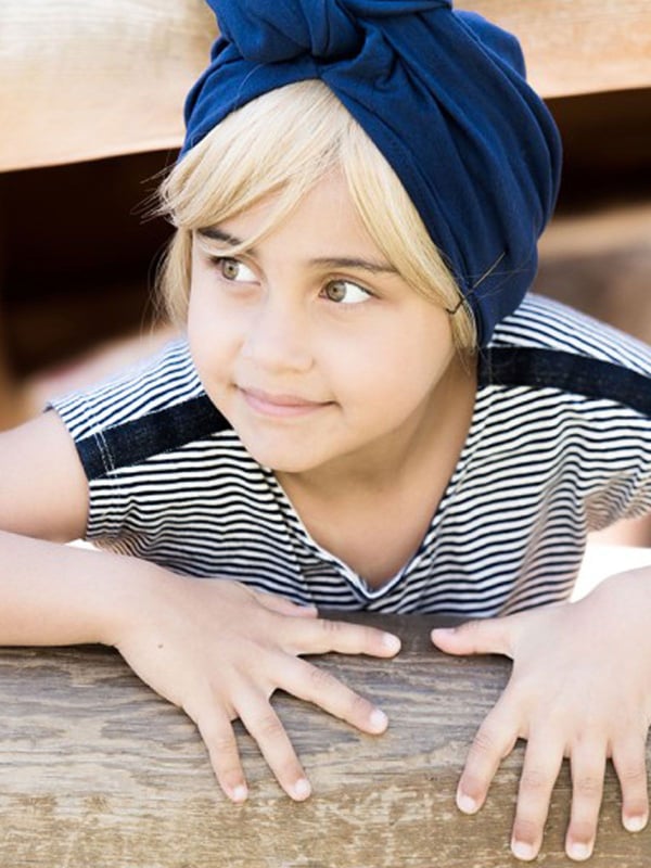Glatte Kinderfransen Les Franjynettes, weiche Kunstfaser, patentiertes Halteband Les Franjynes, ideal unter Turban oder Mütze
