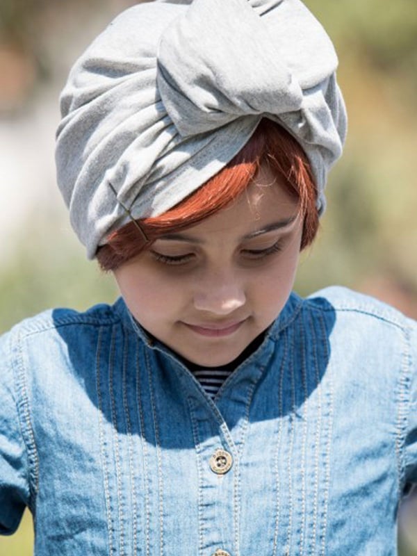 Glatte Kinderfransen Les Franjynettes, weiche Kunstfaser, patentiertes Halteband Les Franjynes, ideal unter Turban oder Mütze