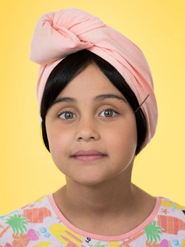 Glatte Kinderfransen Les Franjynettes, weiche Kunstfaser, patentiertes Halteband Les Franjynes, ideal unter Turban oder Mütze