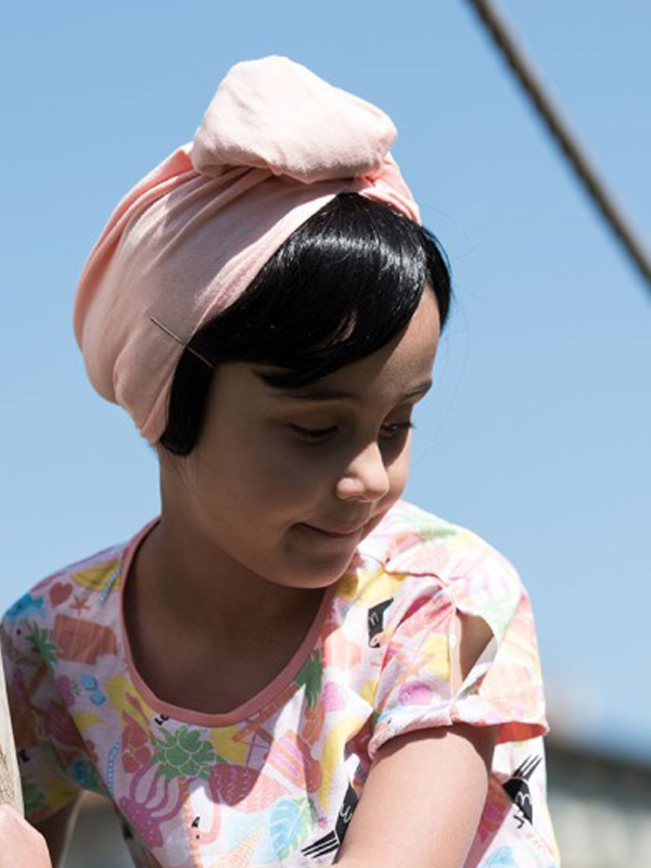 Glatte Kinderfransen Les Franjynettes, weiche Kunstfaser, patentiertes Halteband Les Franjynes, ideal unter Turban oder Mütze