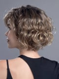 Perücke Turn Mono Part: kurzer lockiger Schnitt, natürliches Volumen, Rooted-Effekt (dunkle Ansätze) oder Mix (Balayage).