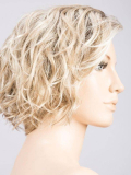 Perücke Turn Mono Part: kurzer lockiger Schnitt, natürliches Volumen, Rooted-Effekt (dunkle Ansätze) oder Mix-Effekt (Balayage).