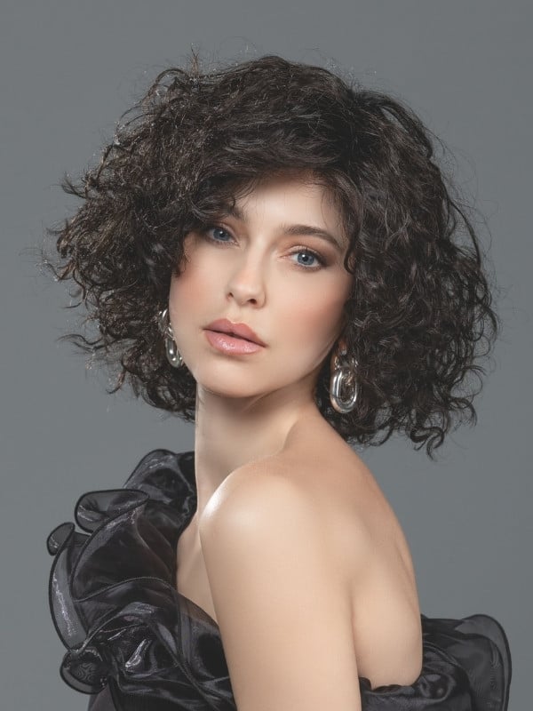 Mittellange, lockige Loop-Perücke von Ellen Wille aus Kunsthaar mit Lace Front, natürlichem Volumen und Standard-Perückenkappe. 