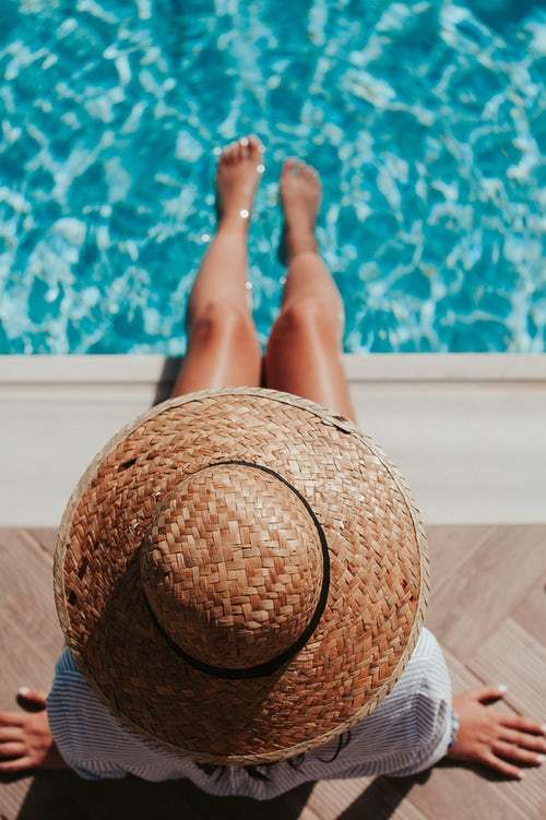 Frau mit Hut und Füßen im Schwimmbad